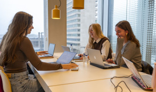 drie studenten studeren achter hun laptop aan tafel