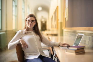 Tevreden studente zit op stoel