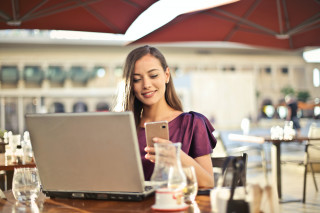 Vrouw in paars met laptop en smartphone
