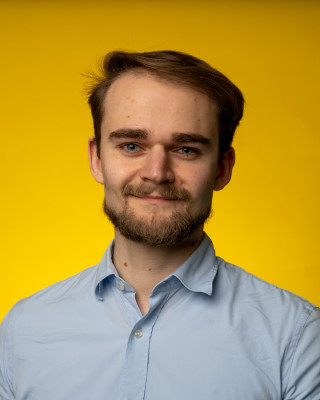 Potretfoto van een man tegen een gele achtergrond