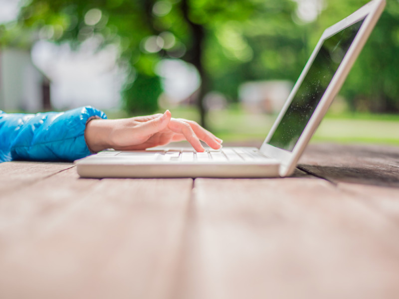 Vrouw buiten achter laptop