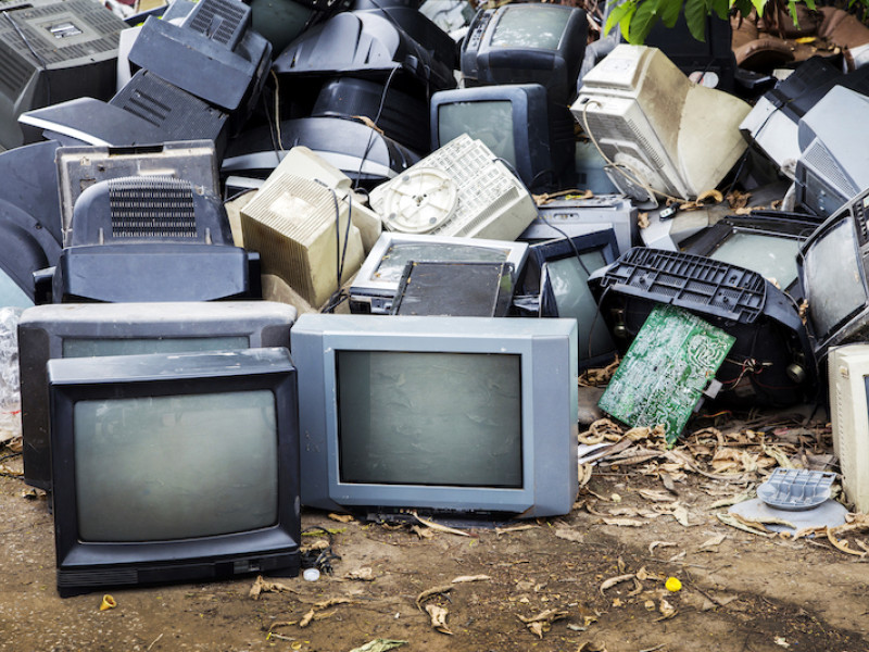 Berg met oude computers buiten op de grond in tropisch klimaat