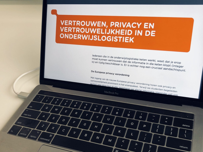 computer met flyer vertrouwen & privacy in onderwijslogistiek op het beeldscherm
