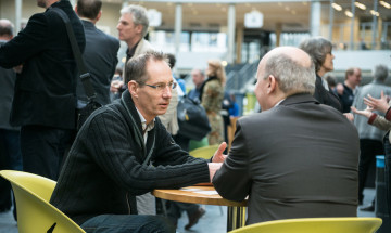 Twee mannen aan een tafeltje met elkaar in gesprek