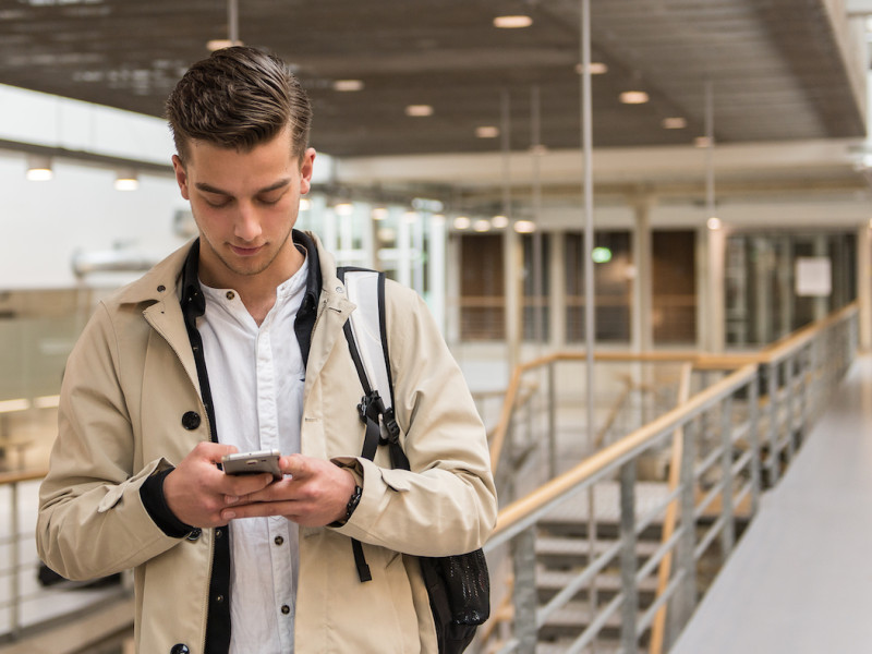 Jongen die op mobiel kijkt