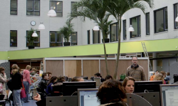 Open ruimte waar studenten achter computers werken
