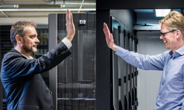 Twee mannen die elkaar een high five geven met datacentrum op de achtergrond
