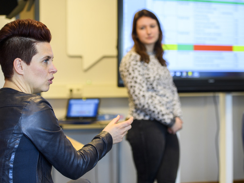 docent legt iets uit aan student