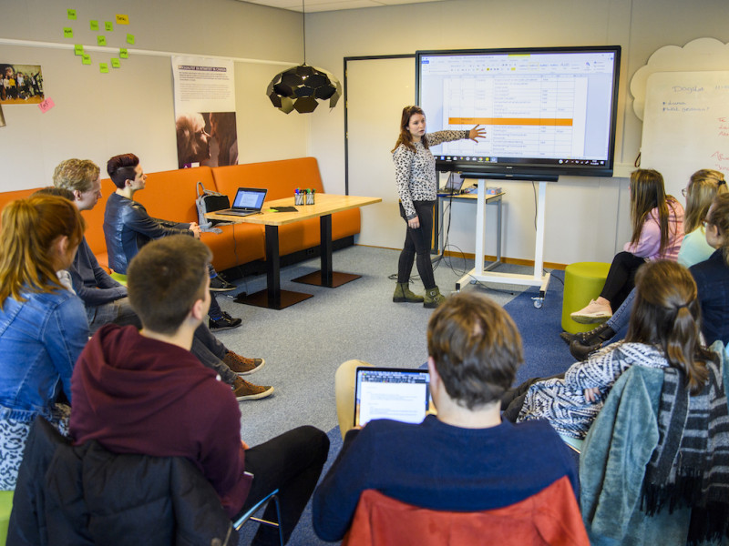 Studenten kijken naar een presentatie van MOOC