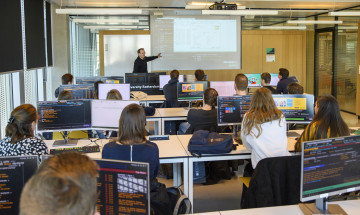 studenten achter computers volgen een college