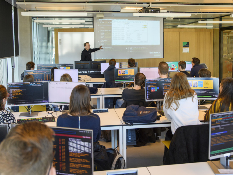 studenten achter computers volgen een college