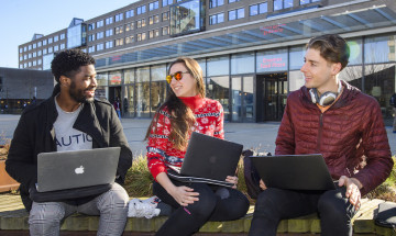 Studenten buiten op een bankje met laptops