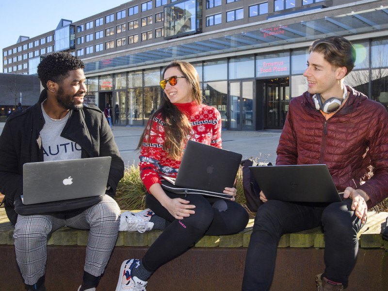 Studenten buiten op een bankje met laptops
