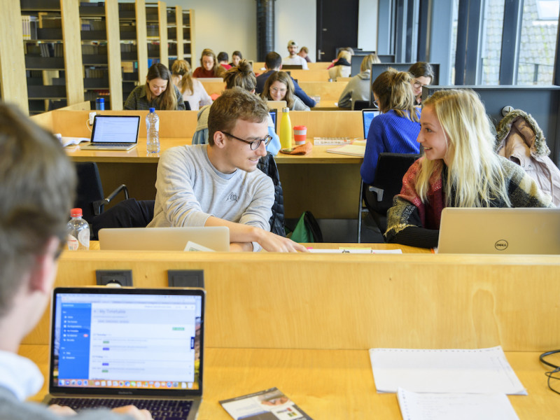 Studenten in de bibliotheek achter computers