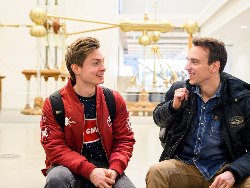studenten zitten op een bankje met jas aan