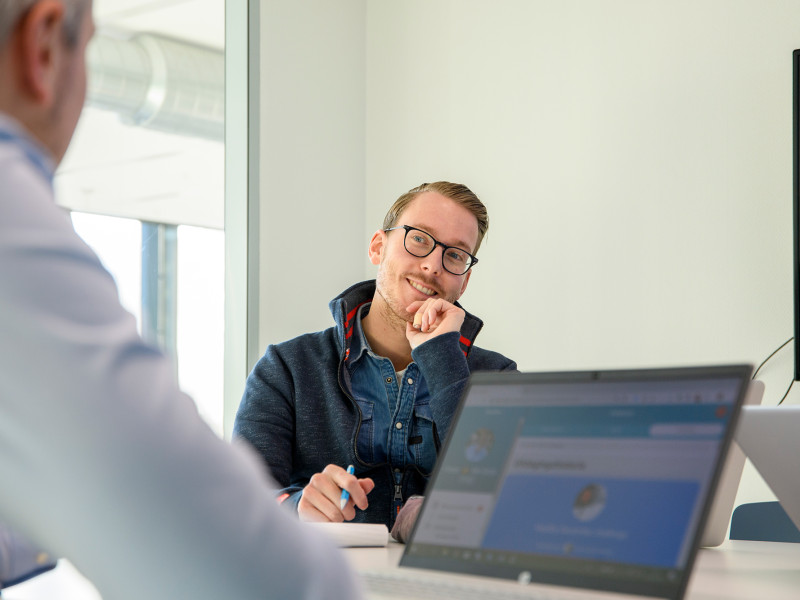 volwassenen in gesprek met laptop