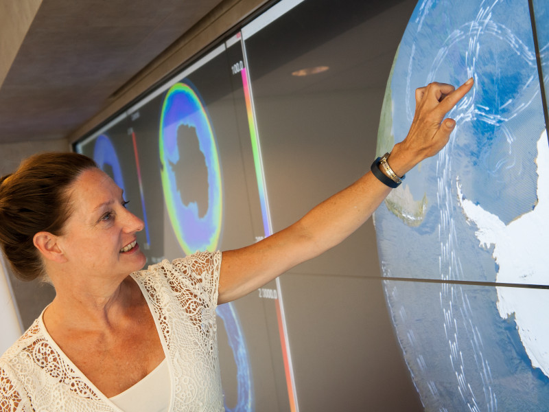 Vrouw wijst op scherm met visualisatie van zeestromingen