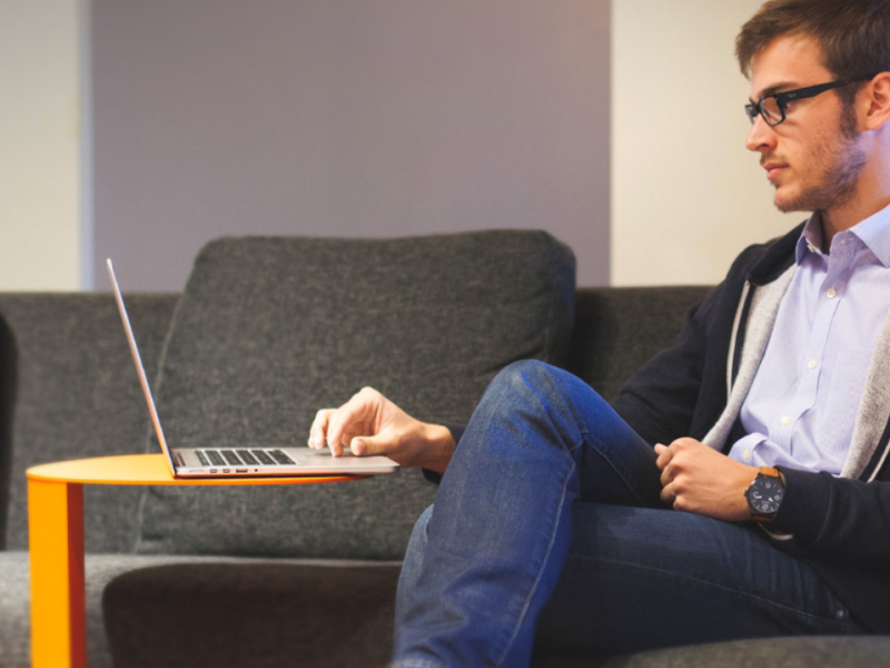 student achter laptop op de bank