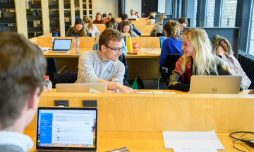 studenten zitten achter laptop en studeren