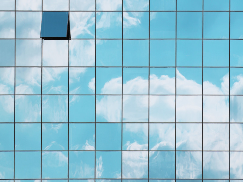 Wolken weerkaatst in raam