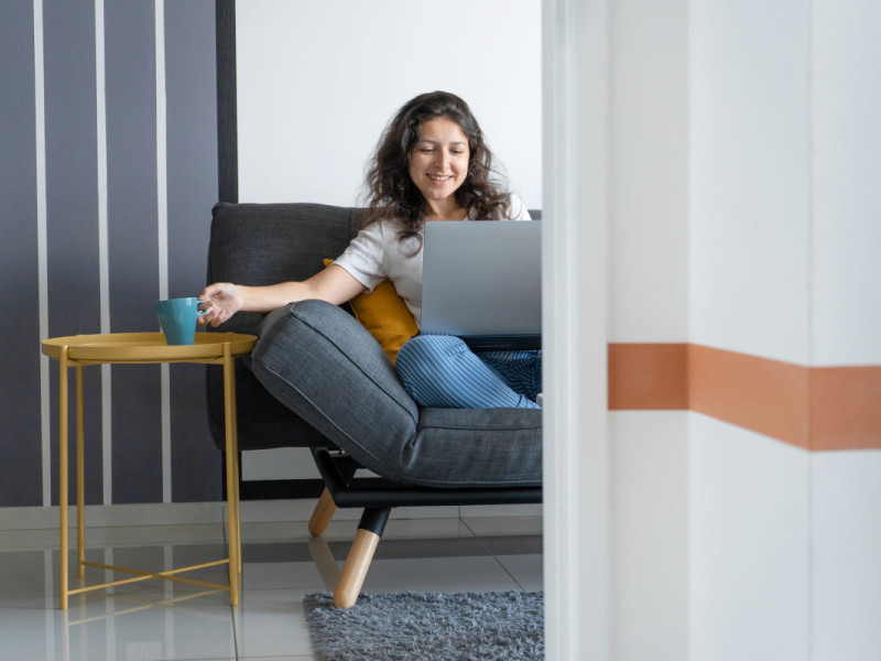 Vrouw achter laptop op de bank