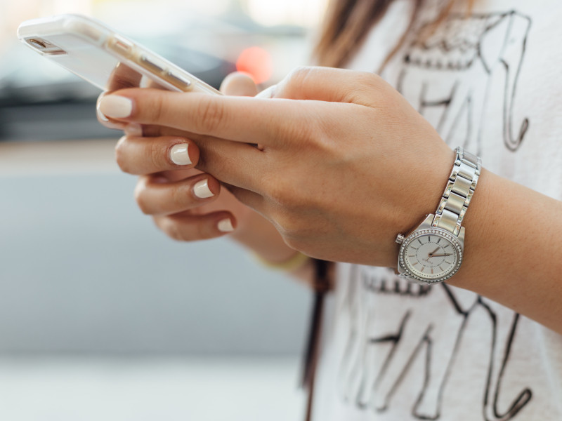 Een vrouw die een telefoon in haar handen heeft.