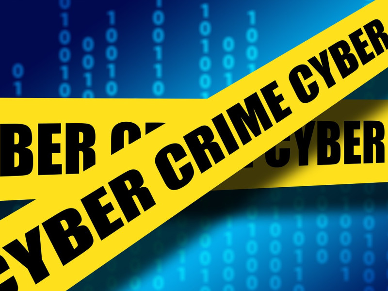 Illustratie van programmeercode met daaroverheen geel tape waarop cybercrime staat