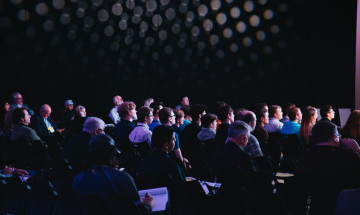Mensen in een grote zaal op een conferentie