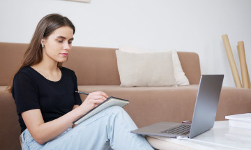 Vrouw met laptop en schrijfgerei