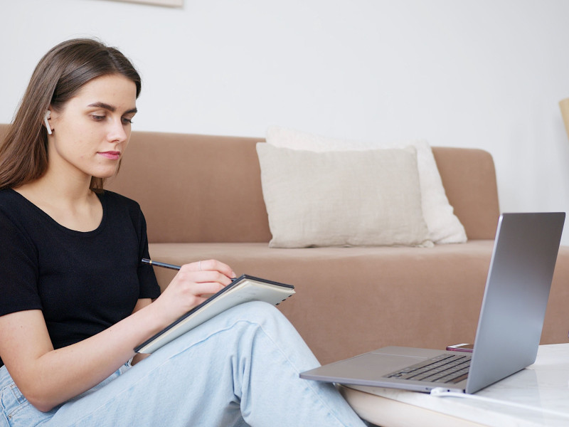 Vrouw met laptop en schrijfgerei