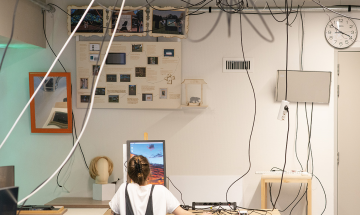 Student van Nimeto achter computer met veel kabels om haar heen
