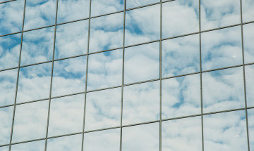 Wolken weerkaatst in glazen gebouw
