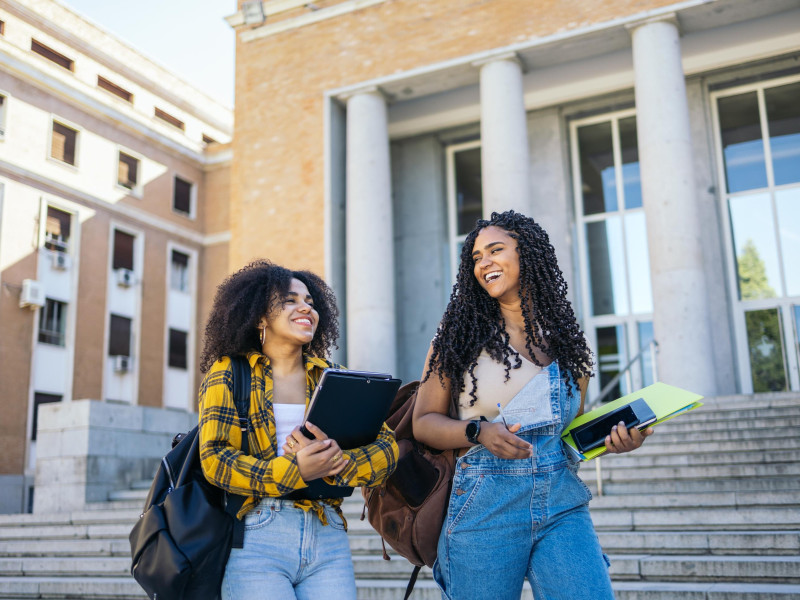 twee studentes die lopen met boeken