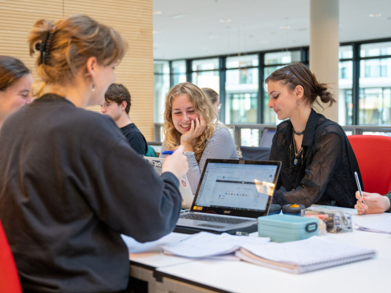 four female students are smiling on their laptops