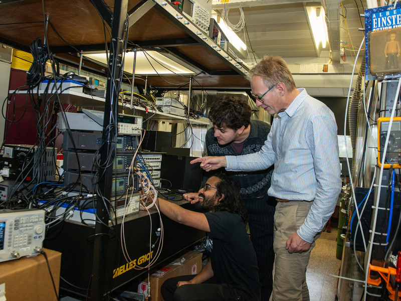 Jeroen Koelemeij aan het werk samen met twee studenten.