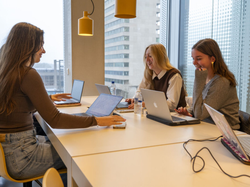 drie studenten studeren achter hun laptop aan tafel
