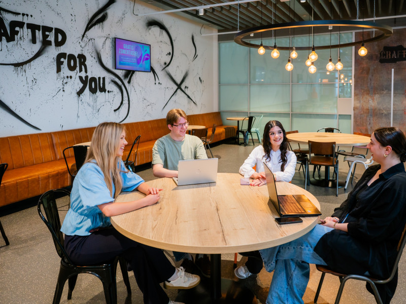 vier mbo studenten van aventus zitten aan een ronde tafel en zijn in gesprek