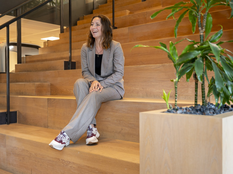 Ellen Mok zittend op trap in het kantoor van SURF