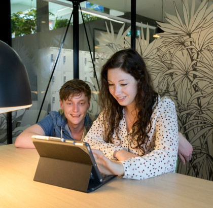 Twee studenten kijken naar het scherm van een tablet