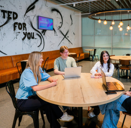 vier mbo studenten van aventus zitten aan een ronde tafel en zijn in gesprek